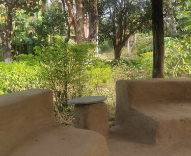 a bench with a table and chairs in a garden