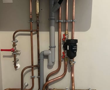 Filtre à boue Sentinel installé sous une chaudière lors d'un remplacement de chaudière