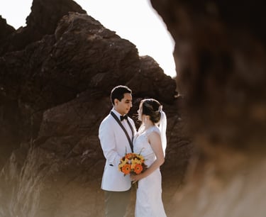 a man and woman standing in front of a rock formation