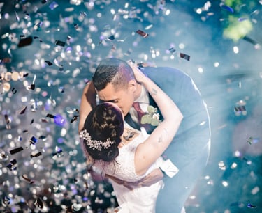 a bride and groom kissing in front of confettittittittittitti