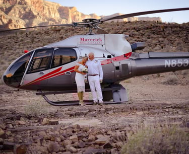 a man and woman standing in front of a helicopter