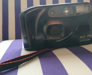 Sobre uma almofada está a majestosa, uma câmera fotográfica de filme do final dos anos 90