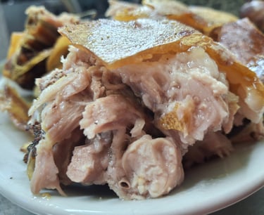 In the photo, Sardinian dinner at a farmhouse near Olbia: Sardinian suckling pig, also known as porc