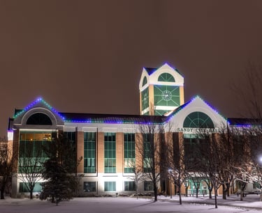 Blue and green lights shining at night that are installed on a town hallhite