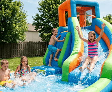 kids on a backyard inflatable water slide