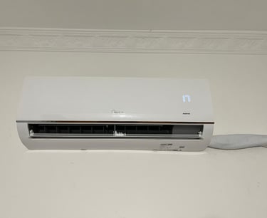 White Midea inverter split air conditioner unit mounted on a wall showing a digital temperature display.