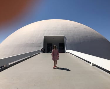 a woman in a pink dress walking down a walkway