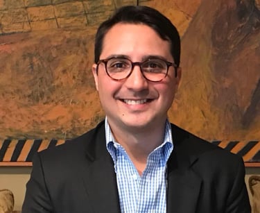 a man in a suit and glasses smiling