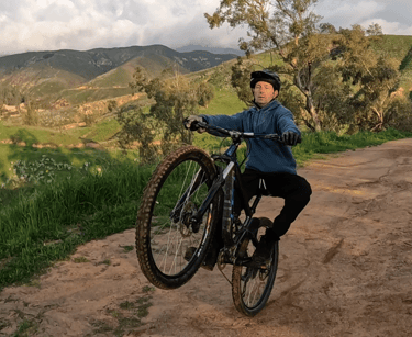 mountain biker practicing using rear brake to keep from looping out on wheelie