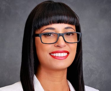 Headshot of a lady with glasses and a white jacket