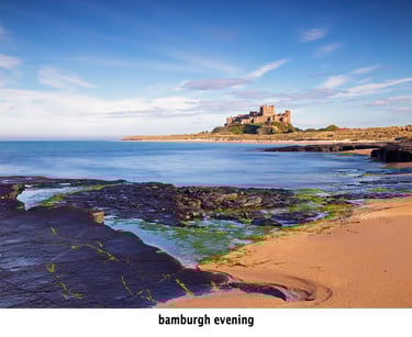 bamburgh castle on the beach in evening light