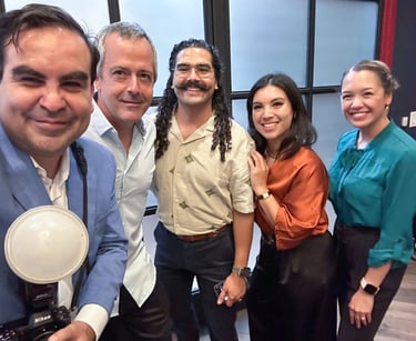 Francisco holds a camera with flash, smiling alongside Hispanic Austin Leadership classmates