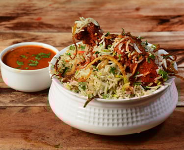 Hyderabadi chicken biryani served with raita, garnished with fried onions and fresh herbs