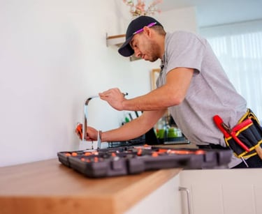 plumber working on kitchen faucet