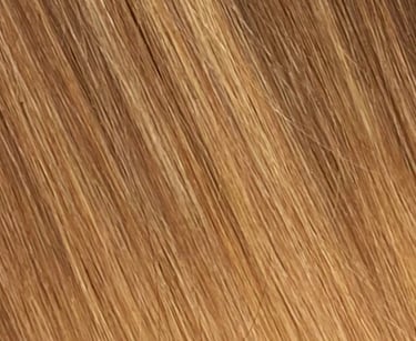 Gros plan de rallonges de cheveux lisses et soyeuses dans un balayage mêlant blond miel chaud et bru