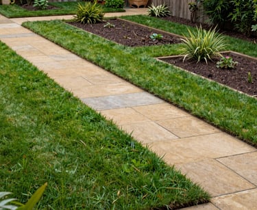 A wide-angle landscape photograph of a fully transformed yard. It features rich, healthy green grass, a clean earthy tan stone path, and organized garden beds with no weeds. The composition is balanced and projects a sense of hassle-free luxury.