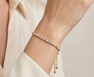 Elegante pulsera tipo tenis de oro y diamantes con cierre deslizante ajustable, lucida en la muñeca 