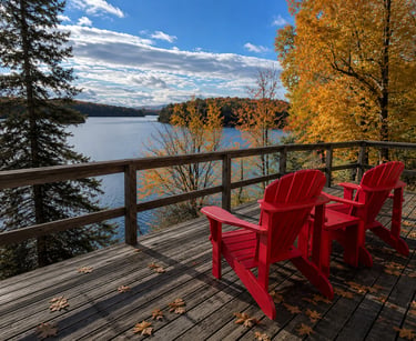 Muskoka chairs facing a lake view at sunset.