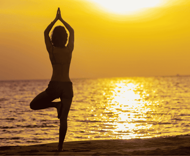 a person doing yoga on the beach
