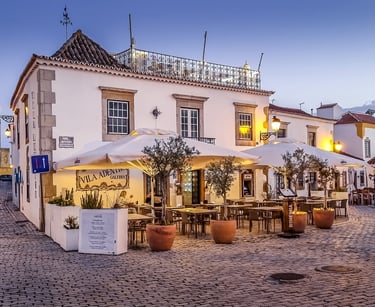 a street scene with a couple of tables and umbrellas