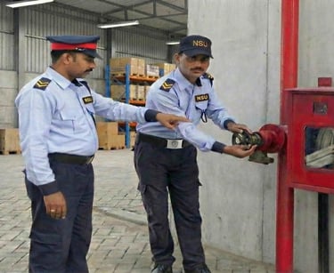 Trained NSU India security supervisor inspecting fire hydrant systems at an industrial warehouse.
