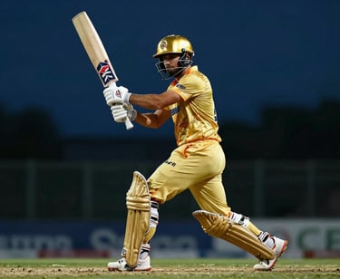 Low-angle action shot of a cricket batsman swinging, golden stadium light reflecting off the helmet, dark blue background.