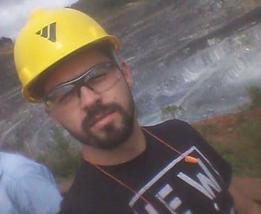  trabalhador equipado com capacete e óculos em meio a uma paisagem de mineração