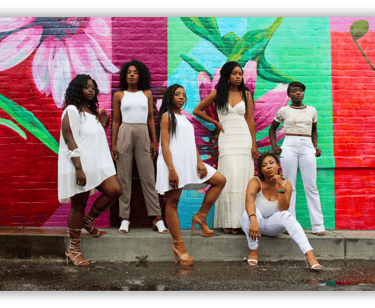 Black women standing in unity against a colorful mural, representing sisterhood, empowerment....
