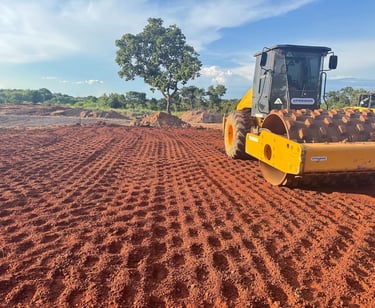 Máquina compactadora realizando terraplanagem em obra de infraestrutura em área rural