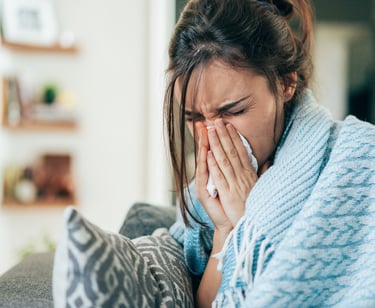 a woman in a blue sweater is holding a tissue paper towel