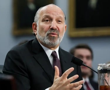 a man in a suit and tie is speaking into a microphone