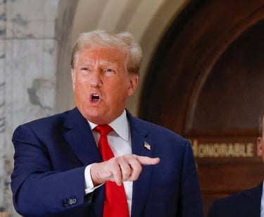 a man in a suit and tie is pointing at a microphone