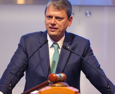 a man in a suit and tie is speaking into a microphone