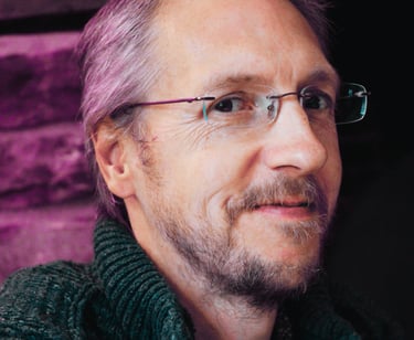 Man smiling, wearing rimless eyeglasses