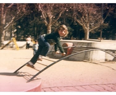 a young boy on a playground with a slider