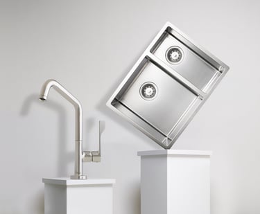 chrome kitchen tap and sink balanced on two white plinths