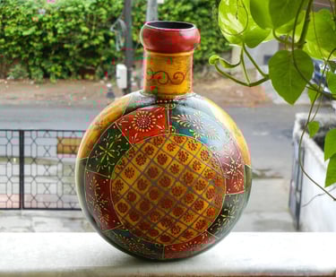 a decorative hand painted glass vase on a balcony