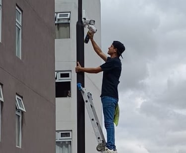 técnico realizando mantenimiento a cámaras de seguridad de un condominio