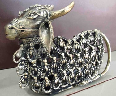 Decorative brass figurine of a sitting bull featuring intricate tribal cutwork design