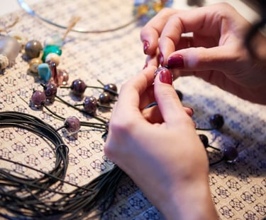 Alumno de taller de macramé elaborando una pulsera a mano.