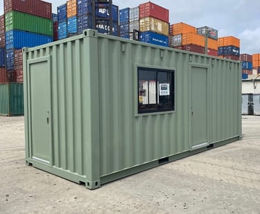 Modified light green shipping container converted into a portable office or site shed in a storage yard.