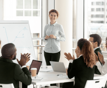a woman in a white shirt and black pants standing in front of a white board