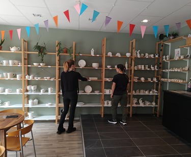 Customers browsing shelves of unpainted ceramic, choosing their favourite