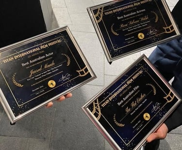 three people holding up plaques with their awards