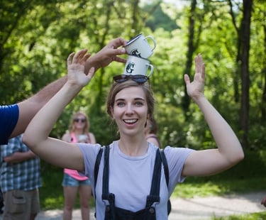 Woman balancing 2 Greenbelt stamped mugs on her head