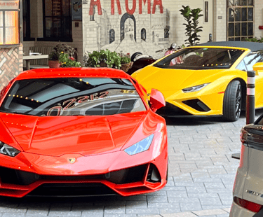 Luxury sports cars parked in front of a building