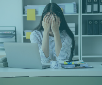 a woman sitting at a desk with a laptop and a laptop