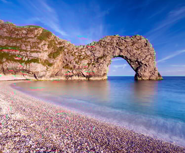a large rock formation in the middle of a beach