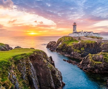 a lighthouse at sunset with a lighthouse in the background