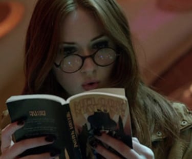 imagem da personagem Emy Pond da serie Doctor Who lendo um livro dentro da Tards